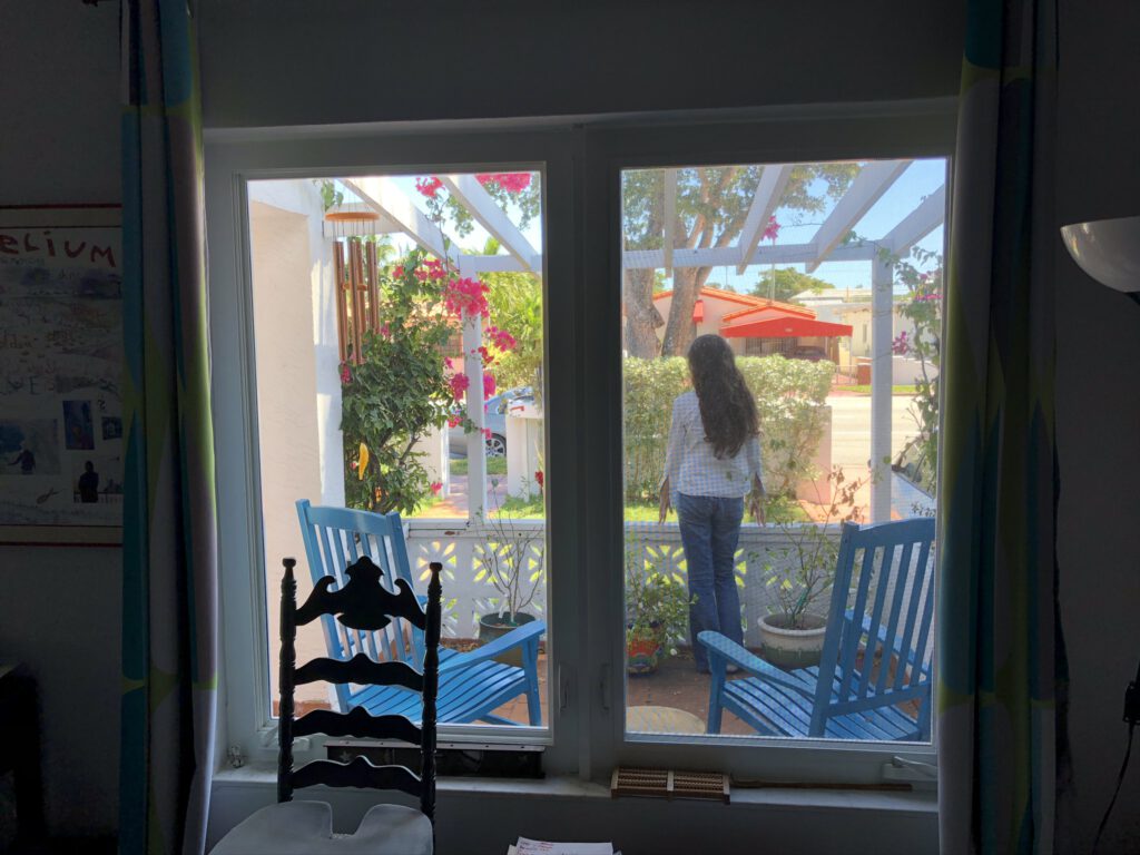 Photo of a woman looking out from her porch
